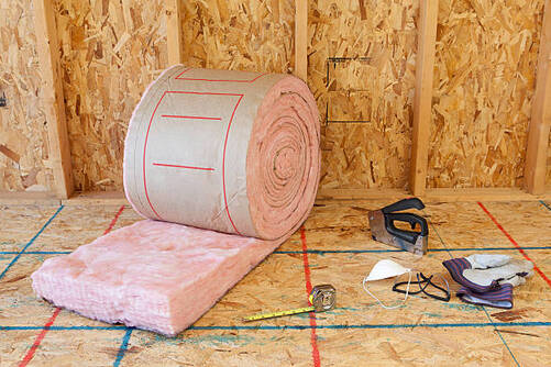 Roll of pink insulation and tools for installation.