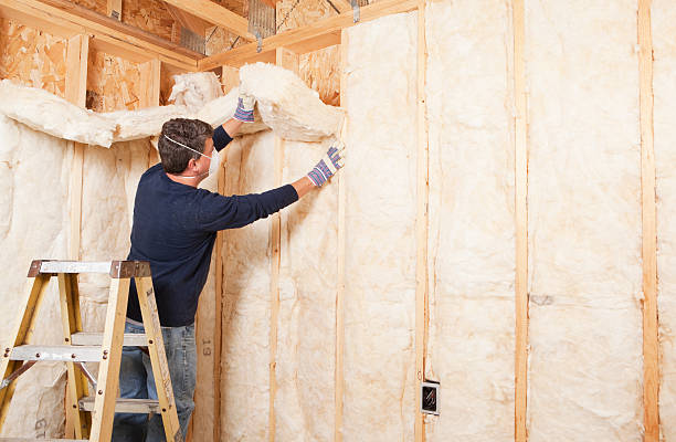 Person installing insulation in the wall of a new residential home in Norwalk, CT.